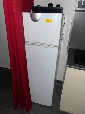 un réfrigérateur blanc dans une cuisine avec un rideau rouge
