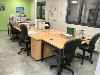 a room with a desk and chairs in it