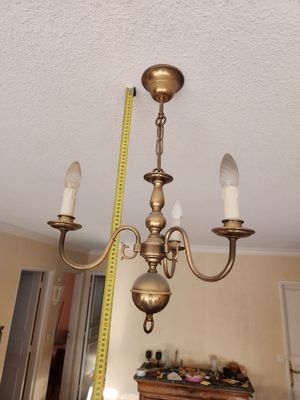une photo d'un lustre avec un mètre ruban au plafond