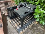 a black skid steer with a red handle sitting on a pallet