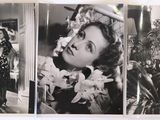 an old black and white photo of a woman with flowers in her hair