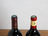 two bottles of wine sitting on a table next to each other