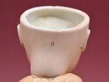 a figurine of a man with a cup on his head