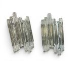 two pieces of silver colored glass are on a white surface