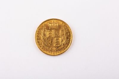 gros plan d'une pièce d'or sur une surface blanche