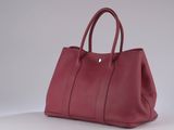 a red leather handbag on a white surface