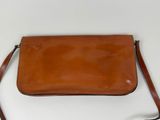 a brown leather purse on a white surface