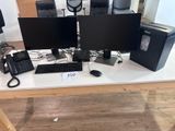 trois écrans d'ordinateur et un clavier posés sur une table