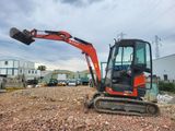 an orange excavator sitting on top of a pile of dirt