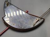 an image of a metal and wood necklace on a gray surface