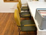 a white table with yellow chairs and a gray box on it