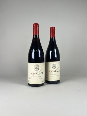 two bottles of red wine sitting next to each other on a table