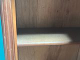 a close up of a wooden shelf with a blue door