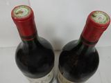 two bottles of wine sitting on top of a table next to each other