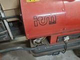 a red tank sitting on top of a machine in a garage