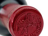 a close up of a bottle of wine on a white surface