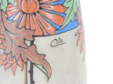 a vase with a flower design on it sitting on a table