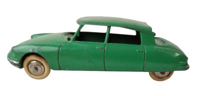 une petite voiture verte posée sur une surface blanche