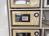 three microwaves stacked on top of each other in the kitchen