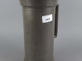 an old metal pitcher sitting on top of a table