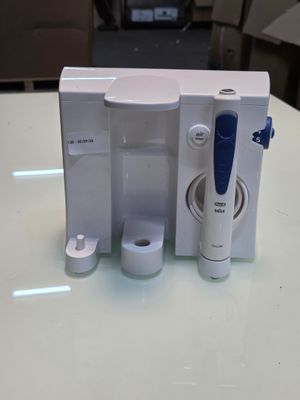 une brosse à dents et un pot de dentifrice posés sur une table