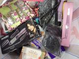 a pile of hair products that are on a bed