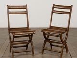 une paire de chaises pliantes en bois posées sur un parquet en bois massif