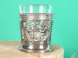 a silver cup sitting on top of a piece of wood