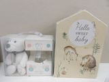 a white teddy bear sitting next to a box of baby products