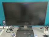 a computer desk with a monitor, keyboard, mouse, and other electronics