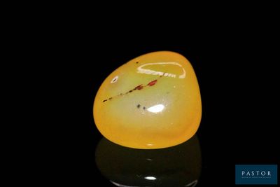 a yellow piece of glass sitting on top of a black surface