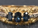a close up of a ring with three different colored stones