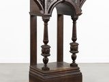 une vieille table en bois avec un plateau sculpté et des colonnes