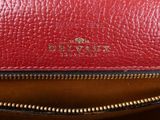 a close up of a red purse with a gold zipper