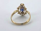 a close up of a gold ring with a blue stone