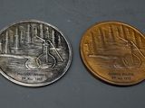 two coins with a picture of a man on a bicycle