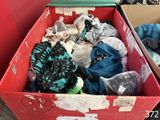 une boîte pleine de vêtements posée sur le sol
