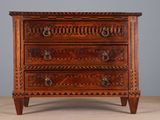 une commode en bois ornée de sculptures sur le dessus