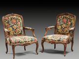 paire de fauteuils en bois sculpté de style Louis XV avec coussins rembourrés à motifs floraux