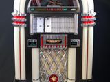 un vieux juke-box est posé sur un socle devant un fond noir