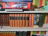 many books that are on a shelf in a room