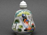 un petit vase avec un oiseau sur une table