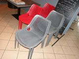 trois chaises placées devant un tableau noir dans un restaurant