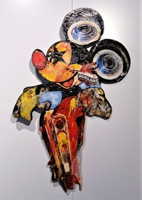a mickey mouse sculpture hanging on the wall of a room