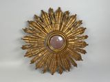un soleil doré rayonnant, orné d'une pierre rose