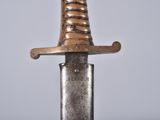a silver knife with a gold handle on a table