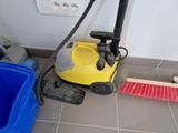 a yellow vacuum cleaner and a blue bucket on the floor
