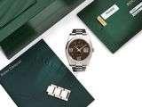 une montre Rolex avec un coffret vert et une carte de crédit