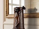 a vase that is sitting on a mantle in front of a mirror