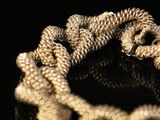 a close up of a silver bracelet on a black surface